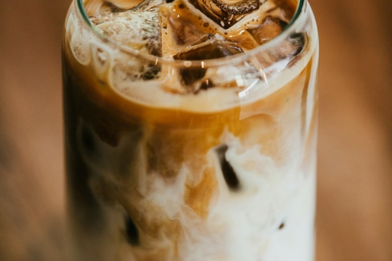 長杯中的冰焙茶歐蕾，牛奶與焙茶在杯中拉出分層的紋理